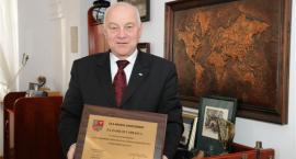 Burmistrz Sandomierza Jerzy Borowski prezentuje grawerton - nagrodę
za zwycięstwo w...